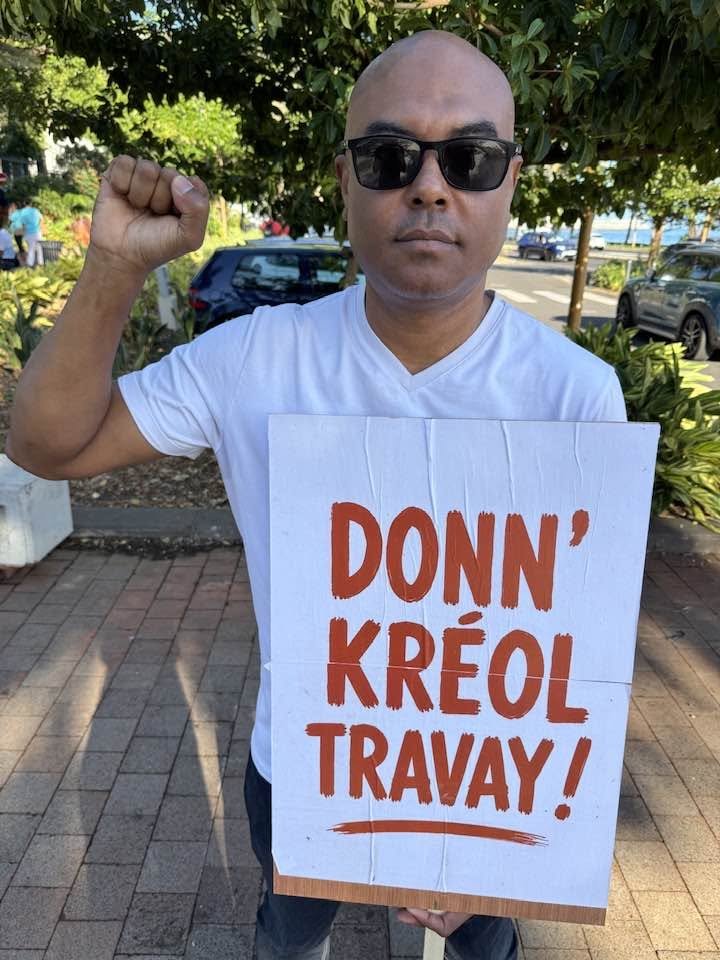 Laurent Médéa, pancarte « Donn’ kréol travay » à la main.